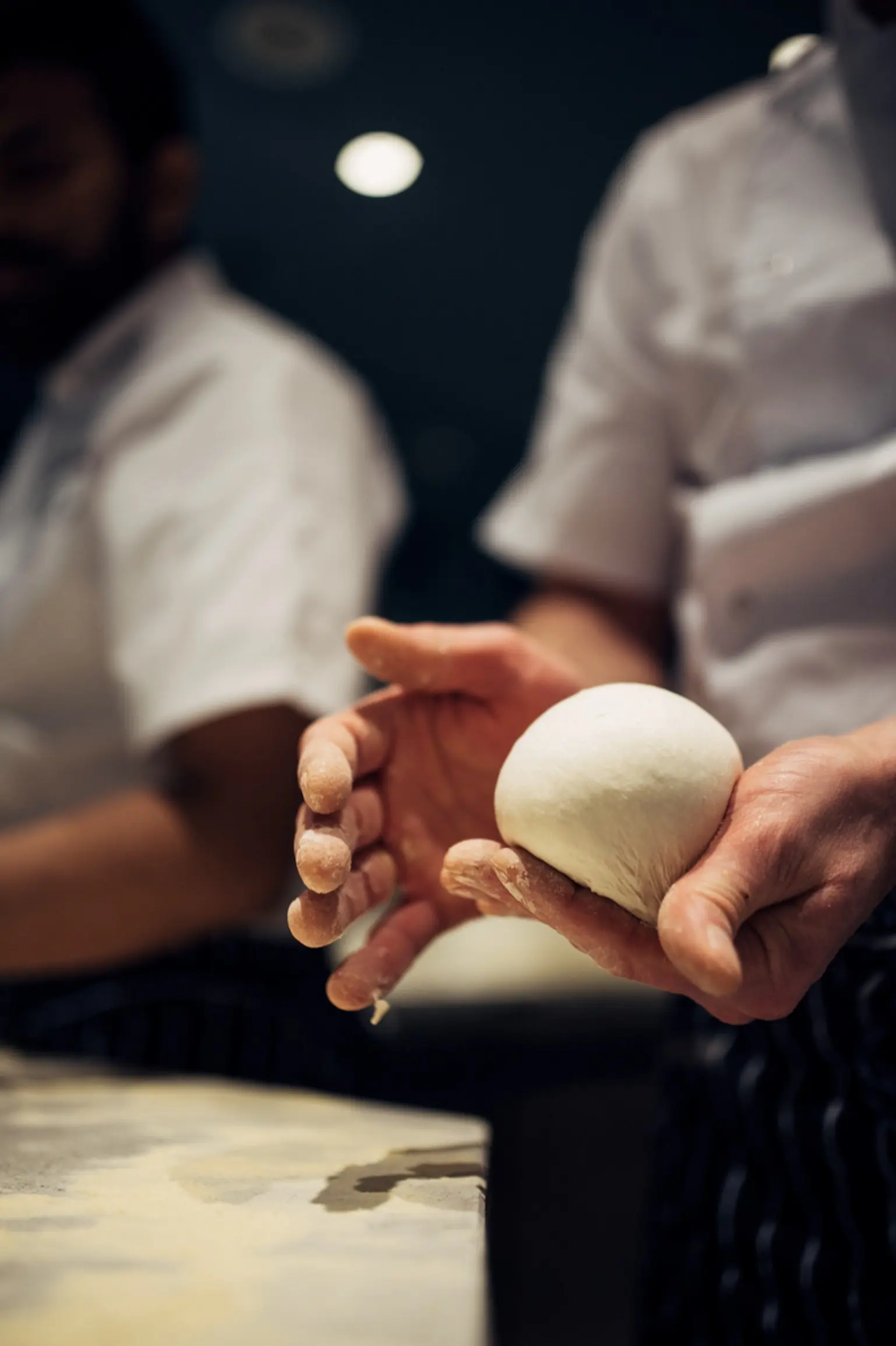 A Bottegas pizzaiolo shaping a ball of Neapolitan pizza dough