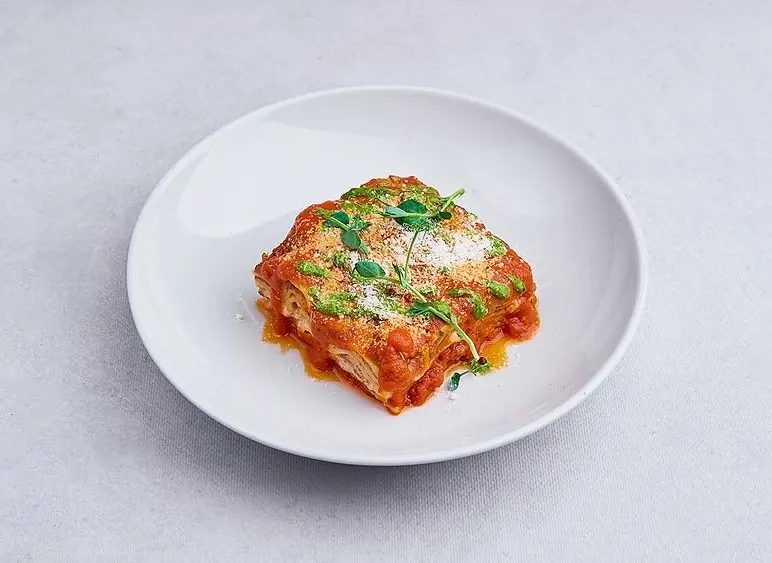 Lasagne al ragù z parmezanem i ziołami na białym talerzu — Bottegas